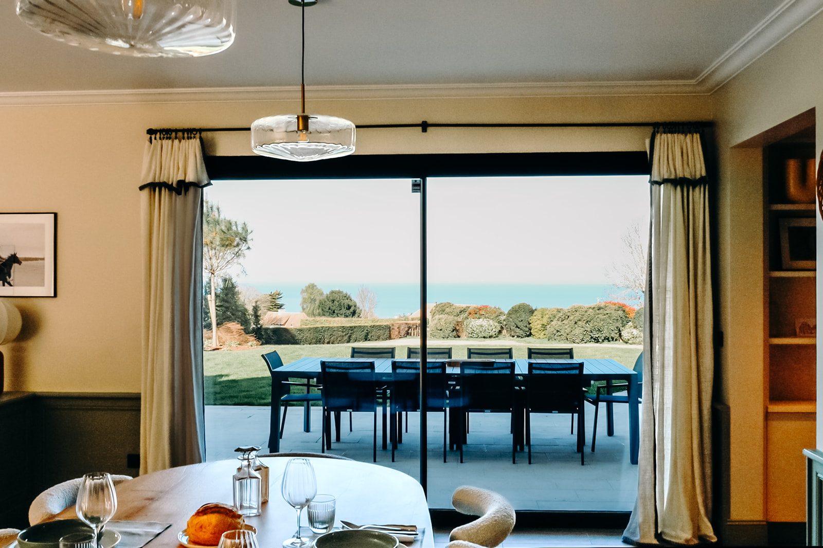The Holisty villa's dining room opening onto the terrace, with the sea on the horizon