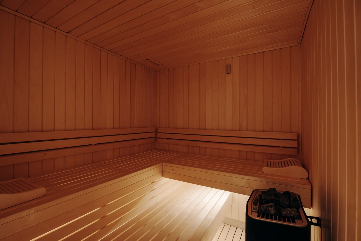 The Holisty villa's private sauna in pale wood, two tiers of benches, seats six