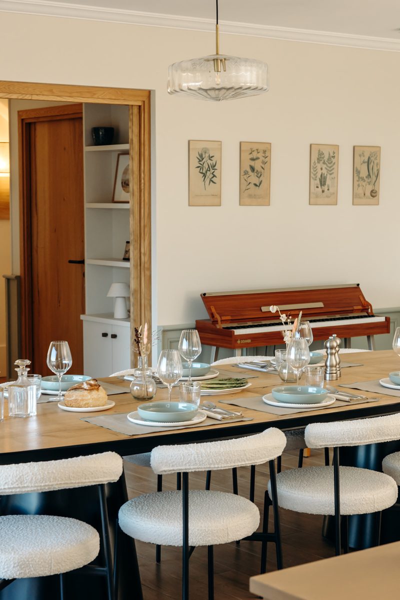 The dining table laid for a meal, the piano in the background