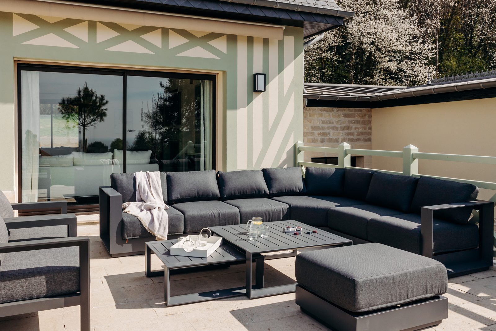 La terrasse de la villa Holisty et ses canapés d'extérieur, face au parc