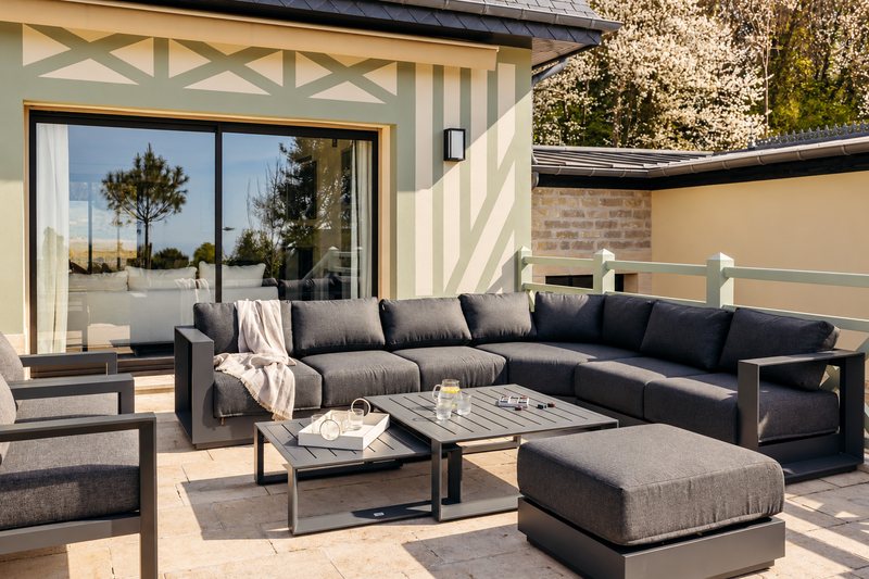 La terrasse de la villa Holisty et ses canapés d'extérieur, face au parc